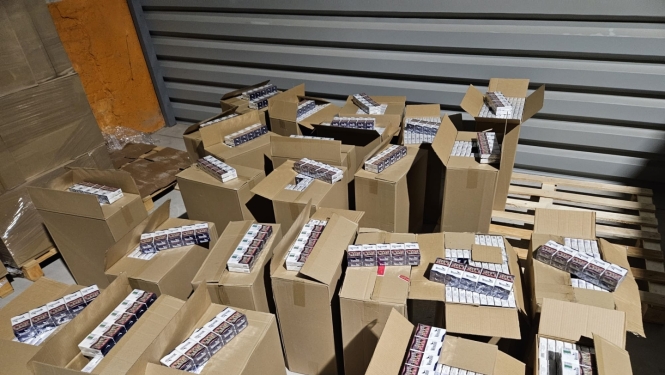 Daudz atvērtas kartona kastes ar cigarešu paciņām