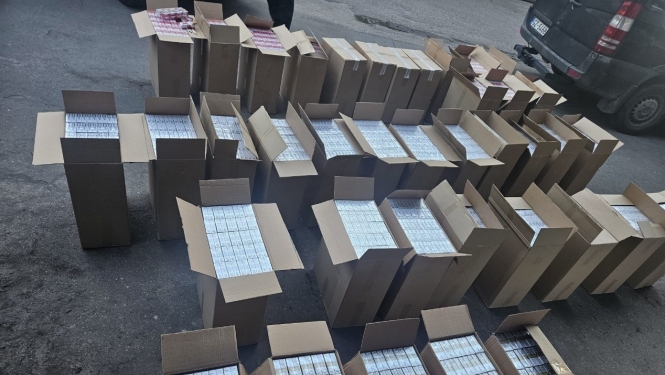 Uz grīdas saliktas daudz atvērtas kartona kastes ar cigarešu paciņām