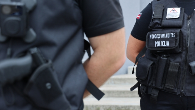 Divi Nodokļu un muitas policijas darbinieki darba formās