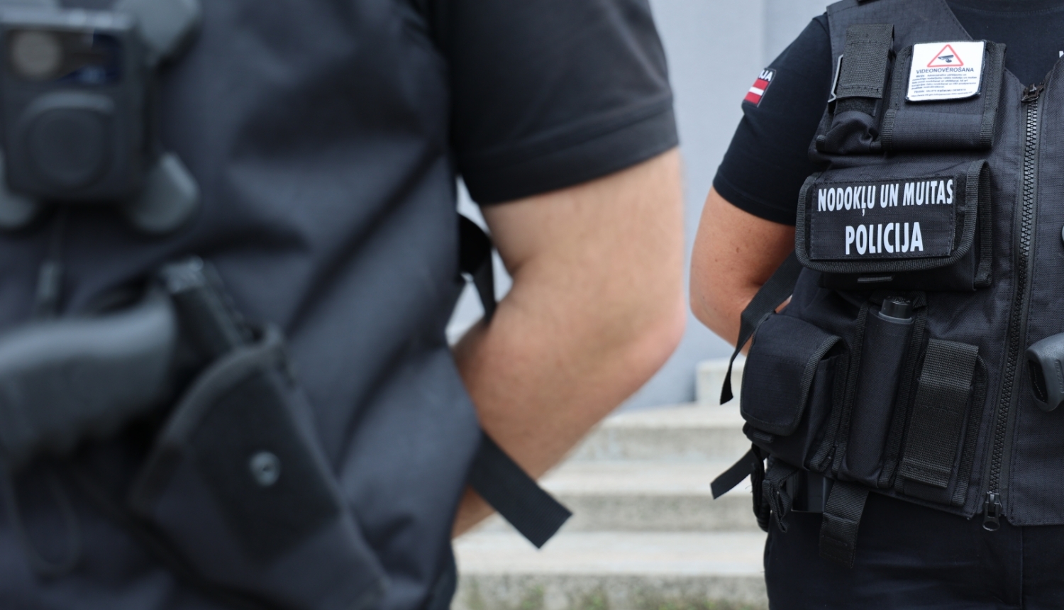 Divi Nodokļu un muitas policijas darbinieki darba formās